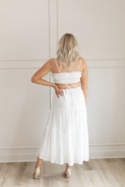 Model wearing white midi dress with side cutouts and smocked bodice